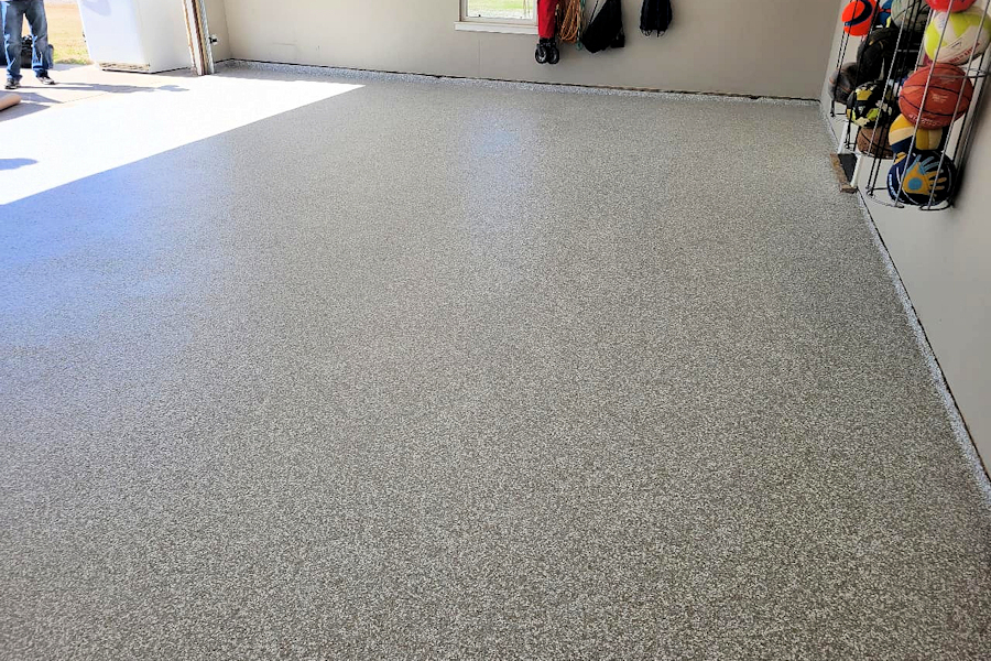 View of a freshly finished epoxy garage floor with a gray, speckled finish.
